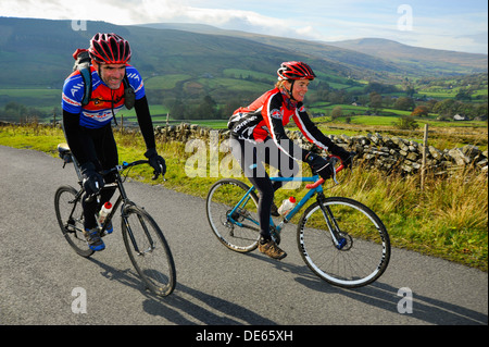 Cyclistes sur la montée raide au-dessus dans le Cowgill Dentdale Yorkshire Dales National Park Banque D'Images