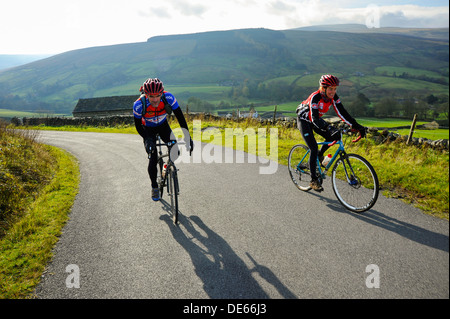 Cyclistes sur la montée raide au-dessus dans le Cowgill Dentdale Yorkshire Dales National Park Banque D'Images