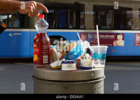 Placer un homme en plastique vide bouteille de boisson fraîche sur le dessus d'une poubelle de rue, Munich Haute-bavière Allemagne Banque D'Images