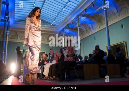 Schwerin, Allemagne. 12e Août, 2013. Présenter les dernières créations de modèles par Andrej Subarew créateur de mode en face de la peinture 'Rhinozeros Clara' par Jean Baptiste Oudry Oudry dans le hall du Musée de l'État à Schwerin, Allemagne, 12 septembre 2013. Le thème de la collection comprenait inspiré de la structure de l'Fischerteppiche Freester à tenue de soirée avec des bijoux de perle et de la peinture de la guerre maritime. Photo : JENS BUETTNER/dpa/Alamy Live News Banque D'Images