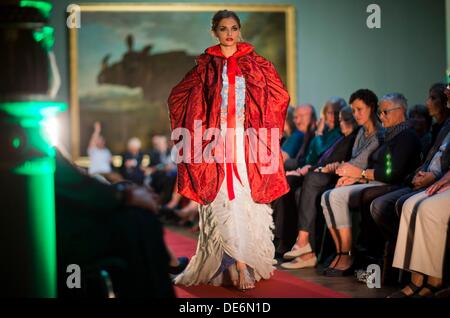 Schwerin, Allemagne. 12e Août, 2013. Présenter les dernières créations de modèles par Andrej Subarew créateur de mode en face de la peinture 'Rhinozeros Clara' par Jean Baptiste Oudry Oudry dans le hall du Musée de l'État à Schwerin, Allemagne, 12 septembre 2013. Le thème de la collection comprenait inspiré de la structure de l'Fischerteppiche Freester à tenue de soirée avec des bijoux de perle et de la peinture de la guerre maritime. Photo : JENS BUETTNER/dpa/Alamy Live News Banque D'Images