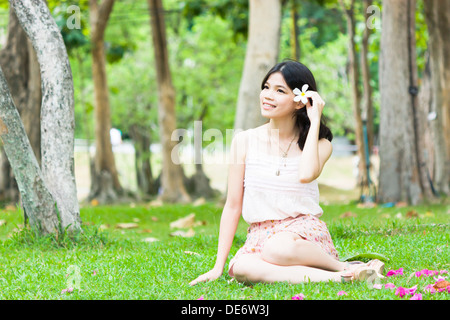 Asian girl avec piscine dans jardin de fleurs Banque D'Images