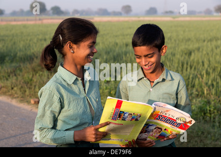 L'Inde, Uttar Pradesh, Agra, frère et sœur dans l'uniforme scolaire à la recherche de manuels indiens à Banque D'Images