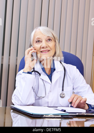 Médecin faisant appel au bureau de l'hôpital de smartphone Banque D'Images