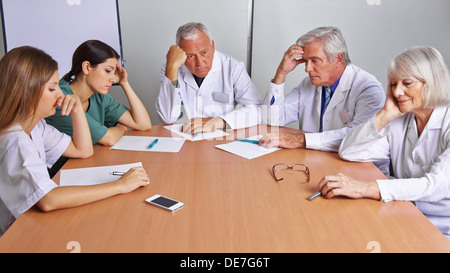 Pensive équipe de médecins et d'infirmières dans une réunion Banque D'Images