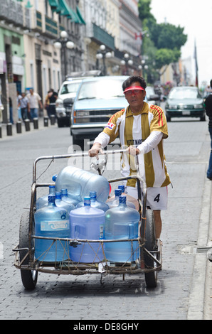 La prestation du vendeur les grands récipients de l'eau sur un chariot pour les entreprises locales dans le centre de Puebla au Mexique Banque D'Images