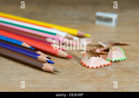 Crayons de couleur avec taille-crayon sur le vieux bureau en bois haut Banque D'Images