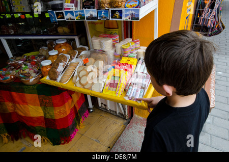 Jeune garçon à la recherche à l'extérieur de l'atelier des bonbons traditionnels mexicains à Cholula au Mexique Banque D'Images