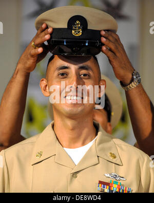 US Navy Premier maître de Manœuvre Gabriel Martinez sourire alors qu'il a sa nouvelle couverture place sur sa tête pendant un premier maître de cérémonie l'épinglage, 13 septembre 2013 au Camp Lemonnier, Djibouti. Dix-huit maîtres de première classe ont été avancés à premier maître au cours de la cérémonie. Banque D'Images