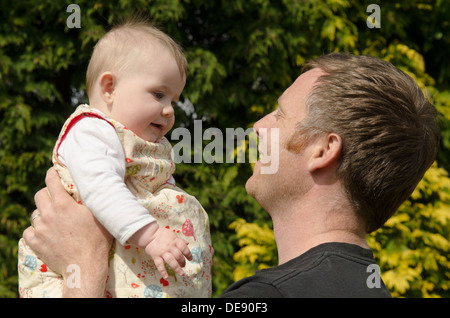 Jeune père avec huit mois baby girl in garden Banque D'Images