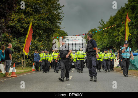 Balcombe, West Sussex, UK . 13e Août, 2013. Camion est escorté par la police sur le chemin de la Cuadrilla site. Indépendamment de toute les manifestants, dont certains ont acclamé et applaudi à partir de la route. Des agents de police avaient à marcher à un rythme rapide.. La fracturation anti écologistes protestent contre les forages d'essai par Cuadrilla sur le site de West Sussex qui pourraient mener à la processus de fracturation controversée. Procédures d'expulsion sont susceptibles d'audience lundi. Avis d'audience a été affiché au site aujourd'hui vendredi. Crédit : David Burr/Alamy Live News Banque D'Images