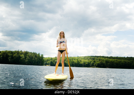 Teen girl stand up paddle sur un lac à Haliburton (Ontario) Banque D'Images