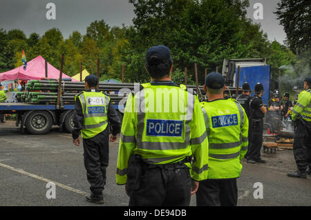 Balcombe, West Sussex, UK . 13e Août, 2013. Des agents de police avaient à marcher plus rapidement aujourd'hui que les manifestants n'entravé la progression de leur escort un autre camion chargé avec des tuyaux percés, Cuadrilla en entrée du site.. La fracturation anti écologistes protestent contre les forages d'essai par Cuadrilla sur le site de West Sussex qui pourraient mener à la processus de fracturation controversée.avis d'expulsion sous réserve de la décision de la cour sur le lundi a été affiché au camp anti fracturation hydraulique. Crédit : David Burr/Alamy Live News Banque D'Images