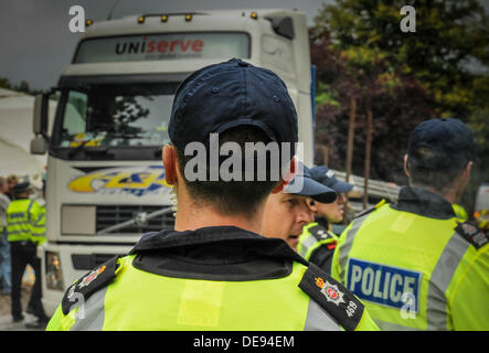 Balcombe, West Sussex, UK . 13e Août, 2013. Des agents de police avaient à marcher plus rapidement aujourd'hui que les manifestants n'entravé la progression de leur escort un autre camion chargé avec des tuyaux, en Cuadrilla entrée du site.. La fracturation anti écologistes protestent contre les forages d'essai par Cuadrilla sur le site de West Sussex qui pourraient mener à la processus de fracturation controversée.avis d'expulsion sous réserve de la décision de la cour sur le lundi a été affiché au camp anti fracturation hydraulique. Crédit : David Burr/Alamy Live News Banque D'Images