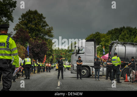 Balcombe, West Sussex, UK . 13e Août, 2013. La ligne de la police de la route, plus de policiers que de manifestants, comme les feuilles de pétroliers Cuadrilla entrée du site... La fracturation anti écologistes protestent contre les forages d'essai par Cuadrilla sur le site de West Sussex qui pourraient mener à la processus de fracturation controversée.avis d'expulsion sous réserve de la décision de la cour sur le lundi a été affiché au camp anti fracturation hydraulique. Crédit : David Burr/Alamy Live News Banque D'Images