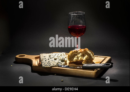 Fromage de Roquefort sur un plateau de fromages avec un couteau à fromage, du pain et un verre de vin Banque D'Images