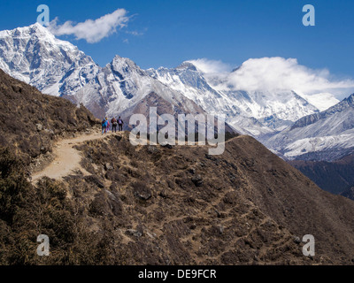 Les randonneurs à pied le long du sentier pour Camp de base de l'Everest au Népal avec le sommet du mont Everest, sombre dans l'arrière-plan. Banque D'Images