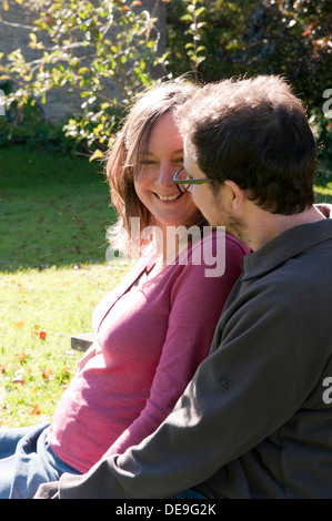 Portrait d'un couple heureux assis dans le jardin Banque D'Images