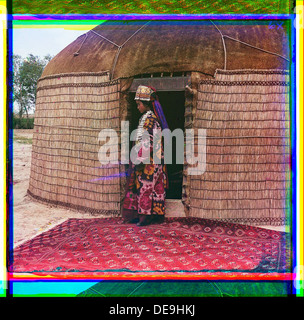 [Profil de pleine longueur portrait d'une femme, éventuellement Turkman ou Kirgiz, debout sur un tapis à l'entrée d'une yourte, vêtus de vêtements traditionnels et de bijoux] (LOC) Banque D'Images