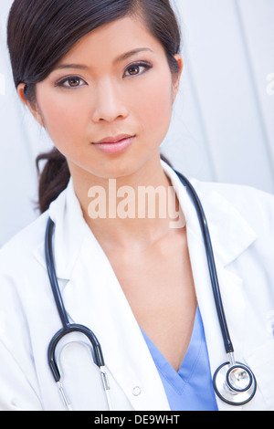 Une femme d'origine asiatique chinois médecin dans un hôpital de porter des gommages corporels, un sarrau blanc et stéthoscope Banque D'Images