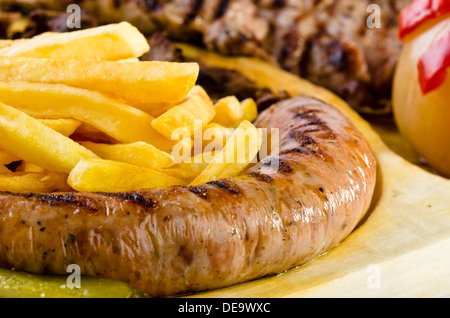 Bac rustique avec différentes viandes, frites et légumes variés Banque D'Images
