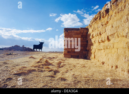 Bottes de paille et Osborne taureau. La province de Cuenca, Castilla La Mancha, Espagne. Banque D'Images