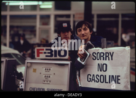 Les préposés à la station-service de Portland sont représentés en train de peindre sur un panneau indiquant qu'il n'y a plus d'essence. L'image illustre un moment de pénurie inattendue de carburant, typique dans les zones urbaines en cas de forte demande ou de perturbations de la livraison de carburant. Banque D'Images