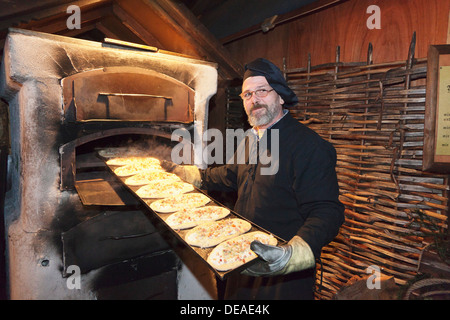 Homme de tartes flambées dans le four, Noël, marché médiéval, Esslingen, Baden Wurtemberg, Allemagne Banque D'Images