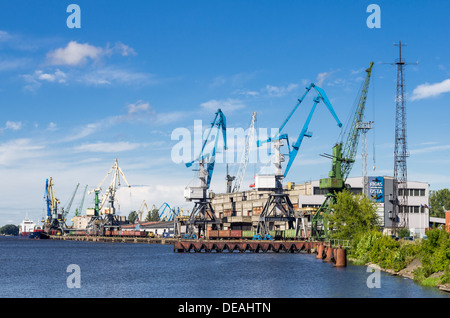 Une vue de l'ancien port du fret à Riga, Lettonie. Avec l'ère soviétique, les bâtiments et les vieilles grues sur une journée ensoleillée. Banque D'Images