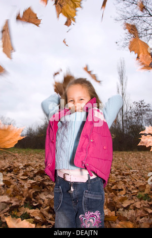 Jouer girl, 4 ans, à l'extérieur à l'automne Banque D'Images