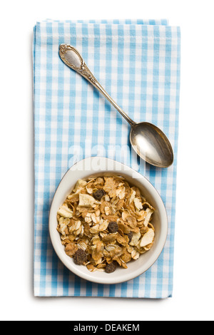 Muesli dans un bol et cuillère en argent sur fond blanc Banque D'Images