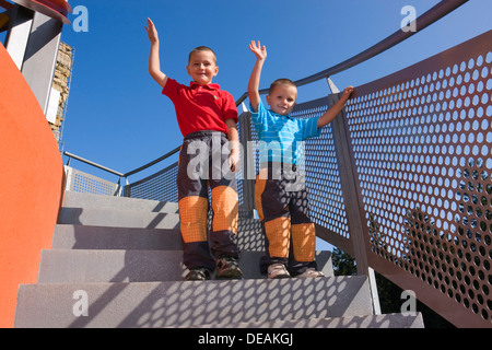 Les garçons, 6 et 4 ans, sur un escalier Banque D'Images