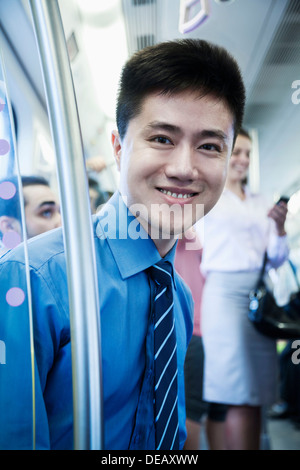 Portrait of young businessman sitting on le métro et regardant la caméra Banque D'Images