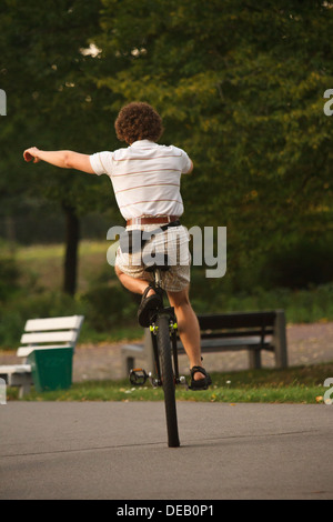 Jeune homme monté sur un monocycle dans le parc. Banque D'Images