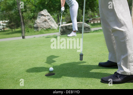 Voir la section basse de l'homme et de la femme le golf et de mettre sur le terrain de golf Banque D'Images
