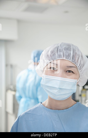 Portrait de chirurgien avec un masque chirurgical et surgical cap dans la salle d'opération Banque D'Images