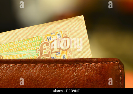 Note de dix livres qui sort d'une pochette en cuir Banque D'Images