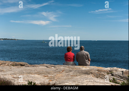 Un vieux couple assis sur les rochers surplombant l'océan au point Judith, Rhode Island USA Banque D'Images