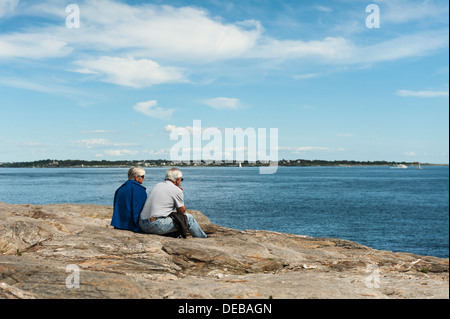 Un vieux couple assis sur les rochers surplombant l'océan au point Judith, Rhode Island USA Banque D'Images