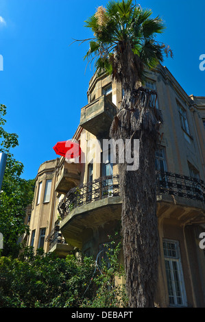 Un parasol au sommet d'un des anciens bâtiments de Tel Aviv au balcon, c'est fameux Boulevard Rothschild. Banque D'Images