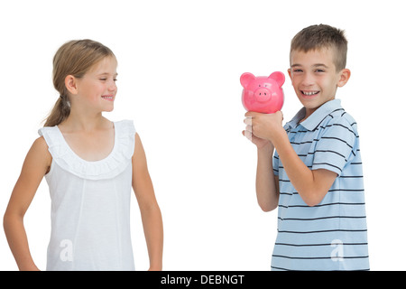 Smiling Young boy holding piggy bank Banque D'Images