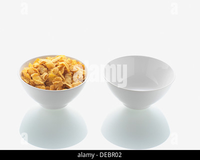 Bol plein de cornflakes et bol vide Banque D'Images