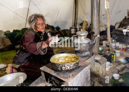 Femme nomade de préparer des aliments à l'intérieur de sa tente, Korzok, Ladakh, le Jammu-et-Cachemire, l'Inde Banque D'Images