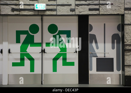 La sortie d'urgence et de toilettes pictogrammes sur les portes de la gare à l'aéroport, Bruxelles, région bruxelloise, Belgique Banque D'Images