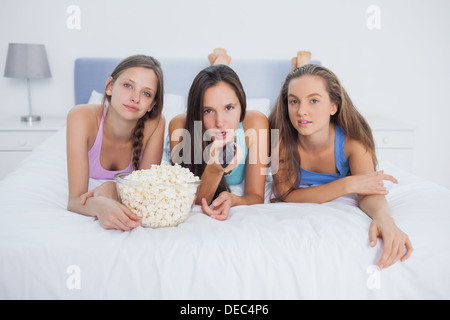 Friends eating popcorn and watching TV Banque D'Images