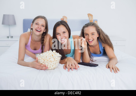 Friends eating popcorn and watching TV Banque D'Images