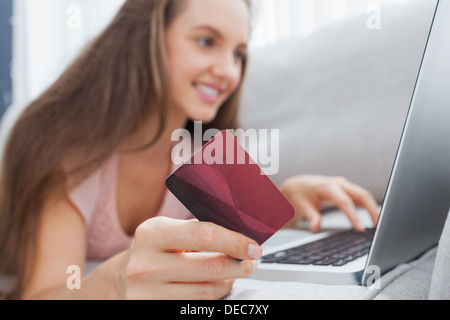 Femme sur le canapé faisant des achats en ligne Banque D'Images