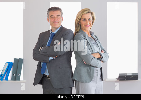 Deux smiling businesspeople à debout dos à dos Banque D'Images