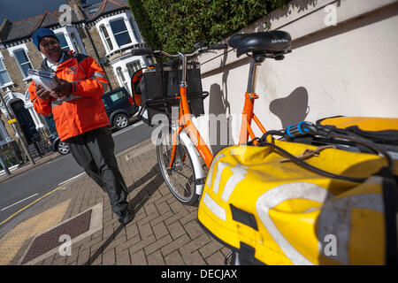 Londres, Royaume-Uni. 16e Août, 2013. La Royal Mail est imminente de portance tout comme ses propres essais TNT service porte à porte dans le sud ouest de Londres. Cela a entraîné l'apparition de facteurs de marque TNT orange distinctive avec les vélos. Ces sont devenues à la fois une curiosité et une menace pour les facteurs traditionnels qui sont 'perplexe' qu'ils peuvent être laissés sans surveillance, déverrouillé et ouvert au vol dans les rues résidentielles, tandis qu'apparemment toujours plein de post. Crédit : Guy Bell/Alamy Live News Banque D'Images
