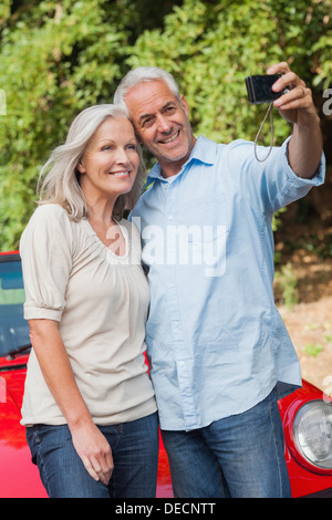 Smiling mature couple prendre des photos d'eux-mêmes Banque D'Images